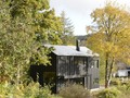 A sloped hillside adds an earthy vibe to the outside to this #uniquehome. #homelove