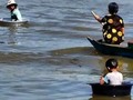 No skateboards in Chong Kneas the floating city. Kids play tag and do tricks in washtubs on the Tonle Sap in Cambodia.