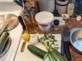 Tzatziki Sauce, condiment, dressing, dip ... Greek sauce made from thick yogurt (yeah! #GreekYogurt!) and finely julienned cucumbers, scallions, minced garlic, fresh mint leaves, fresh lemon zest & juice, dill, and a little olive oil. Tzatziki isn't just for topping Gyros or Spanokapita, it make a cool crisp #Summer dip for crackers, chips, pita wedges, or fresh veggies, and can be thinned a little to use as #SaladDressing! #TonightsDinner #Tzatziki Pic#1 Gather all the ingredients - yogurt, cucumbers, scallions, garlic, fresh mint leaves, lemon, dill, olive oil. Pic#2 Grate or julienne cucumber. I like to julienne and use half a large English cucumber. You can use one regular cuc, just peel it in stripes removing about half of peel, cut in half length ways, and scoop out seeds. With the English cucumber the peel is thinner and seeds much fewer so I just julienne it. After grating or julienning, spread cucumber out over a dish towel and fold over and let sit while you prep yogurt to drain moisture. Just before adding to yogurt roll up tightly and squeeze out as much moisture as possible. Pic#3 Prep yogurt (yes use thick GreekYogurt such as Fage - pronounced Fah-yeah) add thinly sliced scallions, minced garlic, choppes fresh mint leaves, fresh lemon zest, juice of half a lemon (more if you like), a goodly shake of dillweed or chopped fresh dill in season, a little salt and fresh ground black pepper to taste. Blend yogurt well, then fold in cucumber. Pic#4 Top Tzatziki with a dribble of olive oil and serve! If prepping ahead, cover and keep refrigerated until mealtime and serve very cold.