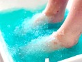 SIEMPRE INNOVANDO... Estás al día en las últimas tendencias en tratamientos de belleza? Si no es así, quizás te sorprenda la nueva técnica que tenemos en nuestro salón: la pedicura de gelatina. Sí, así es, sumergir tus pies en una bañera de gelatina no solo es la nueva moda de los centros de estética, sino que sus múltiples beneficios y ventajas la convierten en el nuevo imprescindible de un ritual de belleza completo.  Jelly Pedi: todo lo que necesitas saber  Una pedicura de gelatina es exactamente lo que su nombre trae a la imaginación, una bañera de gelatina lista para que introduzcas tus pies y juegues con ella entre tus dedos. Para crear esta sustancia es necesario llenar el recipiente de agua caliente y, a continuación, mezclar unos polvos de gelatina especial para cosmética. Esta sustancia especial para los tratamientos de belleza es incluso más viscosa que la gelatina alimenticia y su alto contenido en colágeno la convierte en un elemento particularmente nutritivo y rejuvenecedor para nuestra piel. Uno de los grandes beneficios de este tipo de pedicura es que tiene unas excelentes propiedades exfoliantes. La textura de la gelatina facilita la apertura de los poros de la piel de nuestros pies, por lo que resulta más sencillo eliminar las toxinas que se encuentran en nuestro cuerpo. Por si fuera poco, la gelatina todavía tiene otra propiedad más que nos ayuda a hacer una pedicura completa, y es que la piel tiene un acabado tan suave tras el tratamiento, que resulta mucho más sencillo eliminar la piel muerta tras el baño y conseguir unos pies perfectos para que el tratamiento hidratante penetre profundamente en la dermis. La solución de gelatina ayuda a mantener el calor del agua durante mucho más tiempo. En una pedicura normal, el agua comienza a enfriarse a los diez o quince minutos desde el comienzo de la sesión. En cambio, la gelatina preserva el calor del agua, de forma que se mantiene a una temperatura agradable durante todo el tratamiento. Este efecto no solamente ayuda a realizar limpiezas más profundas, pues los poros se mantienen abiertos durante más tiempo, sino que contribuye a una mejor relajación de los músculos de los pies y favorece la rea