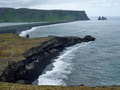 Schwarzer Sandstrand Reynisfjara und die Basaltformation Reynisdrangar, von der Halbinsel Dyrhólaey aus gesehen. Island, 2022.