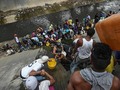Venezuelans collect water from the polluted Guaire River in Caracas, March 11th 2019. A massive power outage continues to cause havoc in many parts of the country. The blackout has added to the woes of Venezuelans who suffer under the regime of Nicolás Maduro. After repelling aid deliveries of food and medical supplies two weeks ago, Mr Maduro declared “victory”. Venezuela's opposition leader Juan Guaidó has been recognised as interim president by more than 50 countries. However, Mr Maduro retains the support of the military and some allies abroad. Credit: AFP/Juan Barreto #crisis #Caracas #Venezuela #starvation #blackout #powercut #water